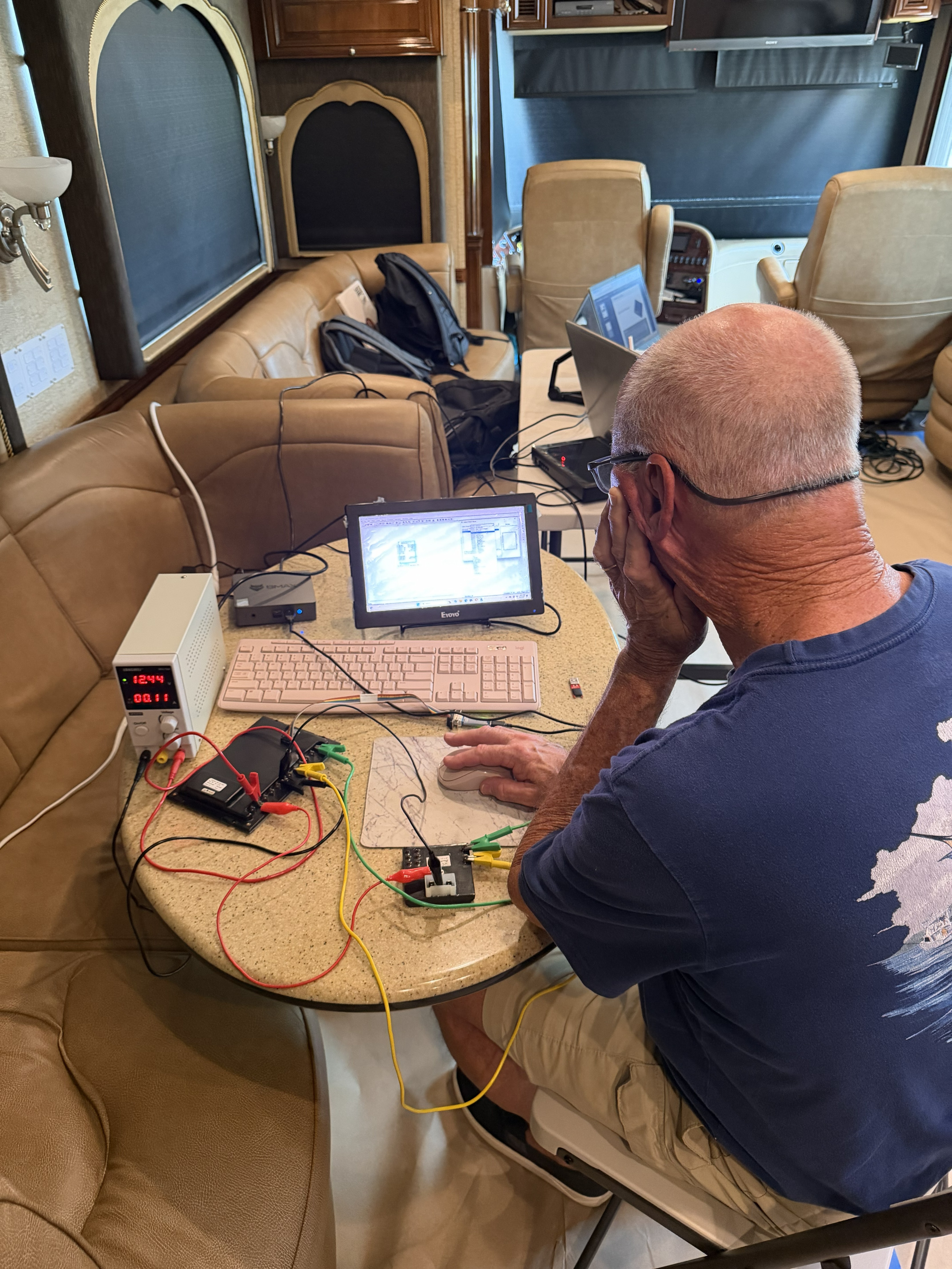 Maritron technician testing wiring and running diagnostics inside a custom coach.